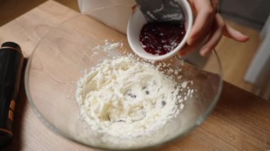 Büyük bir cam kasede vişne aromalı dondurmaya vişne reçeli ekliyorum. Yavaş çekim.