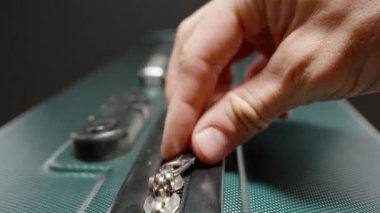 Dolly Slider, kapat. Bir bavulun fermuarını açan, unutulmaz bir yolculuğun sinyalini veren, rutinden kaçmaya ve rahatlamaya hazır bir elin yakın çekimi..
