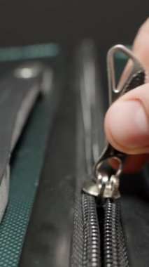 Dikey video. Dolly Slider, kapat. Parmaklar fermuarı tutar, valizi kapatır macera ve keşif yolculuğu için son hazırlıklar yapılır..