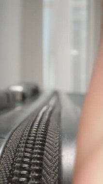 Dikey video. Dolly Slider, kapat. Bir valizin fermuarını açıp rahatlama ve macera yolculuğundan önceki anı yakalayan parmaklar..