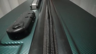 Parmaklarını bağla fermuarı valizin kombinasyon kilidine çek, bavulun yolculuk için güvenli bir şekilde kilitli olduğundan emin ol..