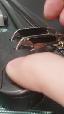 Dikey video. Bir El, şifreyi nasıl kullanacağını gösteriyor. Fermuarı açmak için şifreyi değiştiriyor..