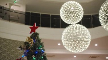 Parlak Işıklar ve Kırmızı Yıldızlı Adorn Bir Festive Hotel lobisindeki Noel Ağacı.