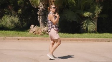 Kadın, Palm Trees ve Lush Yeşillik 'in yanından geçerken, 