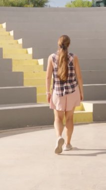 Dikey video. Geniş Amphitiyatroda Parlak Sarı Adımlar Azalan Kadın Yapı Merkezinde Hareket Ediyor. Yavaş çekim.