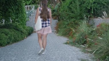 Yeşil ve Kırmızı Yapraklarla kaplı Taş Yol 'da Yürüyen Bir Kadın Bir Merdivene Yaklaşıyor..