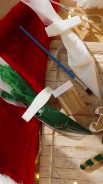 Dikey video. El Tutma Noel Ağacı Kurabiyesi Sarı ve Kırmızı Madalyalı, Arka planda Tatil Sahnesi.