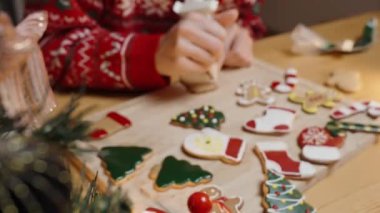 Kadın Kalp Şeklinde Kurabiye, çeşitli Noel kurabiyeleriyle çevrili, Şen Süveter Giyen, Güneşli Noel Sabahı.