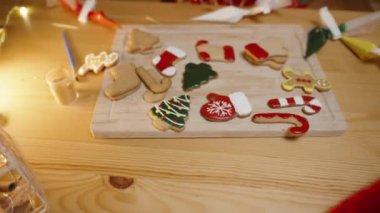 Sıcak Tatil Işıkları Altındaki Çorap ve Ağaçlar dahil olmak üzere Noel kurabiyeleriyle süslenmiş bir masa..