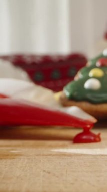 Dikey video. Ağaçlar ve Çoraplar da dahil olmak üzere dekore edilmiş Noel Kurabiyeleri ve Arka planda bir Noel Ağacı. Dolly kaydırıcı, kapat..