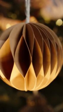 Dikey video. Zarif Tasarımlarla Noel Süsleri Döndürme, Parlayan Tatil Işıklarının Arkaplanına Karşı Set.