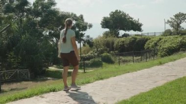 Çevresi yeşillik, eskrim ve arka planda okyanusla çevrili, Gökyüzü açık güneşli bir gün..
