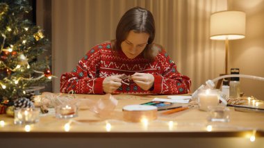 Bayram Işıkları ve Malzemeleri ile çevrili, Kırmızı Şenlikli Süveter Giyen, Süslü Bir Kadın.