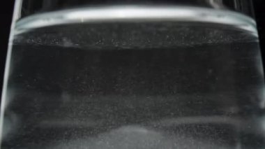 Suda dönen çözülmemiş toz parçacıkları karıştırma sürecini vurguluyor.