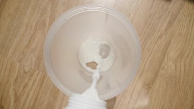 Sütün karıştırıcıya boşaltıldığı yavaş çekim videosu, dökümü yakalamak için içeri giren kamera. Dolly kaydırıcı, kapat..