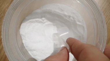 Az miktarda kreatin tozu içiyorum, istenilen dozu dikkatlice ölçüyorum. Dolly Slider, kapat. Yavaş çekim.