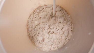 Protein tozunun üzerine süt dökerek protein zengini bir karışım yaratmaya hazırlanıyor..