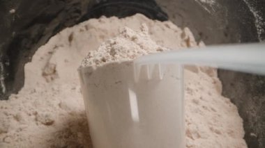 POV Protein tozuyla dolu bir kepçenin yakın plan görüntüsü, kavanozdan çıkarıyor. Kaydırıcı