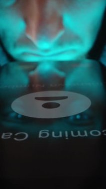 Dikey video. Bilinmeyen Numara 'yı gösteren bir telefon ekranının üzerinde gezinen ve bilinmeyen bir çağrıya cevap vermeden önce tereddüt eden bir kişinin yakın plan görüntüsü. Dolly kaydırıcı, kapat..