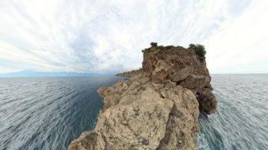 360 derece panorama. Her iki tarafında sonsuz su bulunan kayalık bir uçurumun okyanusa açılışı. Video geniş açılı çekiliyor, dramatik kıyı manzarasını gösteriyor..