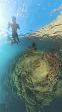 Dikey video. Bir Dalgıç Büyük Kaya oluşumunun üzerinde yüzer, Su Yüzeyi 360. Delik Gezegeni, Küresel Panorama Efekti, Sahne 'ye Gerçeküstü Bir Dokunuş Ekler.