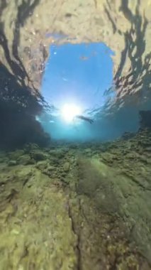 Dikey video. Bir dalgıç, Güneş Işığı 'na doğru Rocky Tüneli' nden yükselir, 360. Delik Gezegen Küresel Panorama Efekti ile yakalanır, Sualtı Mağarası 'nın Derinliğini ve Ölçekini Gösterir..