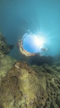 Dikey video. Bir dalgıç, Güneş Işığı 'na doğru Rocky Tüneli' nden yükselir, 360. Delik Gezegen Küresel Panorama Efekti ile yakalanır, Sualtı Mağarası 'nın Derinliğini ve Ölçekini Gösterir..