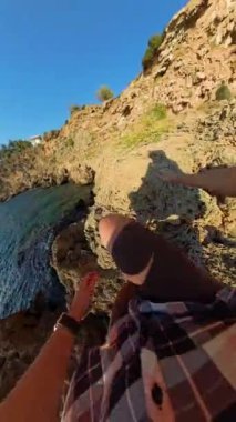 Dikey video. Rocky Cliffs 'e tırmanan bir kadının ilk insan görüntüsü, Eller Sahile, Sahile, Sahildeki Kayalıklara ve Okyanusa uzanırken, 360 Küresel Panorama' da yakalandı..
