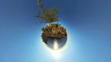 Ufukta Güneş Batarken Okyanusa Bakan Küçük Gezegen Efekti 'ndeki Uçuruma İki Kişi Dinleniyor.