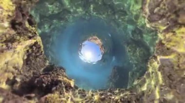 360. Gezegen Deliği küresel panorama. Büyük bir kaya oluşumu berrak suyun altında, güneş ışığı yüzeyde parıldıyor, kayaların etrafında yumuşak bir parıltı yaratıyor..