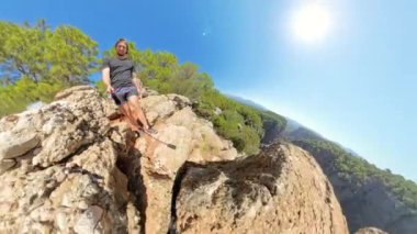 Küçük Gezegen etkisi, etrafındaki kayalar ve ağaçlar etrafında dönerken bir adamın uçurumun kenarında durduğunu gösteriyor. Derin Kanyon ve parlak güneş dramatik manzaraya ekleniyor..