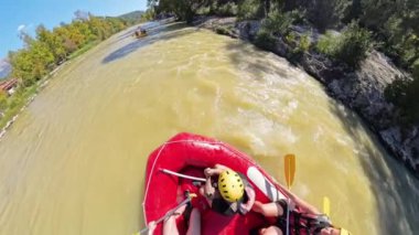 Ağaçlarla çevrili çamurlu bir nehirde kürek çeken bir grup kirişçinin yukarıdan çekimleri rafting deneyiminin takım çalışmasını ve heyecanını yüksek açılı bir perspektiften yakalıyor..