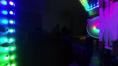 Yakınlaş, dışarı. Parlayan RGB ışıklarını, soğutma vantilatörlerini ve donanım bileşenlerini vurgulayan bir oyun bilgisayarının süper geniş açılı görüntüsü. Çekim, karanlık bir ortamda bilgisayarın içindeki karmaşık düzeneği gösteriyor..