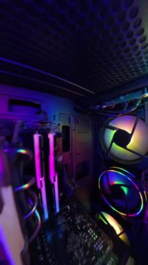 Dikey video. Bir oyun bilgisayarının içindeki dinamik kamera hareketi, RGB 'nin aydınlattığı bileşenlerin ve donanımın yakın çekim görüntülerini gösteriyor. Çekim, aydınlanan fanlar, soğutma sistemi ve kamera çantanın içinde hareket ederken detaylı bölümleri vurguluyor..