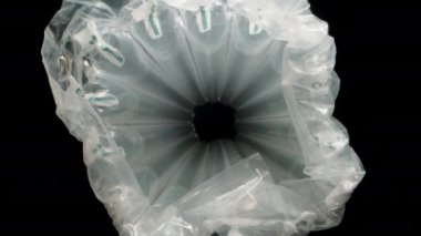 Silindirik plastik hava ambalajının yakın plan görüntüsü katmanlı kabarcık dokusunu merkezde karanlık dairesel bir boşlukla gösteriyor ve bir tünel etkisi yaratıyor. Dolly kaydırıcı, kapat..