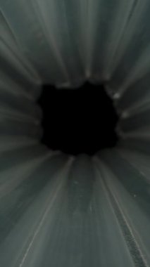 Dikey video. Tünel benzeri bir formda hava dolu silindirik ambalajların yakın plan çekimleri, koruyucu plastik baloncuklarını radyal düzende boş bir merkez odak ile vurguluyor. Dolly kaydırıcı, kapat..
