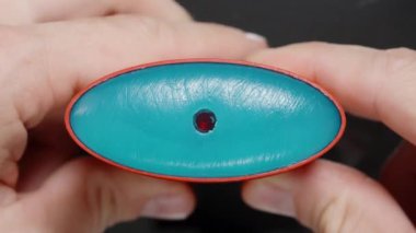 Katı bir deodorant çubuğunu tutarken ve bükerken ellerin yakın çekimi, konteynerin oval şeklini ve içerideki ürünün pürüzsüz dokusunu gösteriyor, kişisel bakım ve hijyeni vurguluyor..
