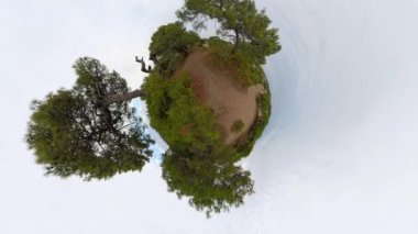 Ağaçlarla çevrili kumlu bir yolun 360 derecelik görüntüsü küçük bir gezegenin görüntüsünü veriyor. Bu etki küresel bir manzara yaratır ve doğal manzarayı gözler önüne serer..