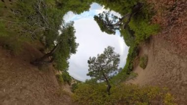 Çarpık bir perspektif, bulutlu hava koşulları altında denizi gösteren dolly zoom görünümüne geçiş yapan tünel benzeri bir etki yaratır..