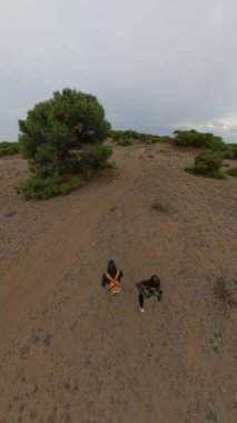 Dikey video. 360 derecelik bir kamera, kumlu bir patikanın çarpık bir perspektifini yakalar..