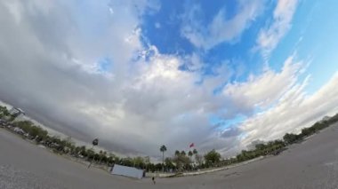 Dönen bir hava perspektifinden çekilen çakıl taşı plajının geniş açılı görüntüsü dalgaları, ufku ve dramatik gökyüzünü dinamik bir sahnede dağınık bulutlarla gösteriyor..