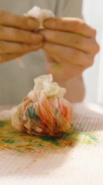 Dikey video. Güneşli bir odada boya kaplı bir paspasın üzerinde sarılmış bir Paskalya yumurtası yuvarlamak..