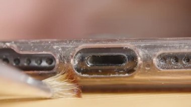 Akıllı telefon şarj portu ve hoparlör delikleri son derece yakın gösterilir, iyi bir temizlik fırçası dikkatle toz ve enkazı temizler