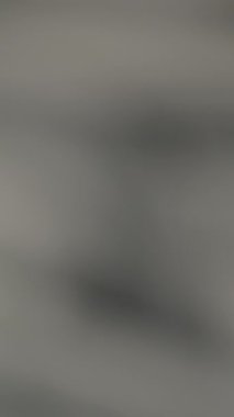 Dikey video. Yüzlerce dolarlık banknotların yakın plan çekimi dağınık bir para yığınının üzerine düşüyor, keskin detaylar ve bulanık bir perspektifle ağır çekimde çekiliyor.
