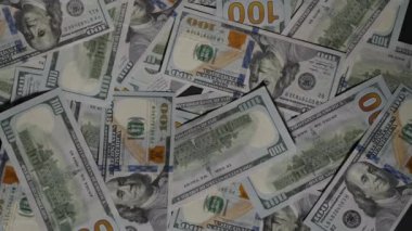 Yüz dolarlık banknotlar dağılır ve çerçevenin dışına uçar, siyah arkaplanda tek bir banknot bırakır, bu da finansal tükenmeyi ya da kalan son kaynağı sembolize eder