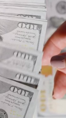 Dikey video. Bir kadına vermek için yığınla para saymak ve 10 dolarlık banknotun el değiştirmesi.
