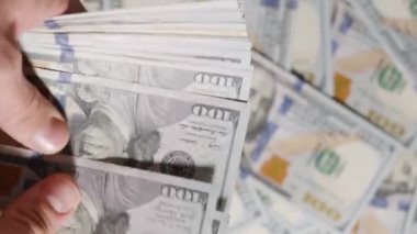 Büyük bir yığın yüz dolarlık banknottan, sadece on dolarlık bir banknot veriliyor, bu da değer eşitsizliğini ve asgari ödülü vurguluyor.