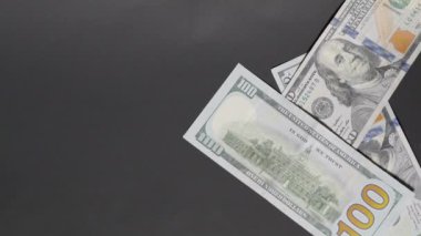 Yüz dolarlık banknotlar çağlayarak aşağı iniyor, yüzeyi tamamen dinamik bir nakit akışıyla kaplıyor, finansal bolluk ve refah ortamı yaratıyor.