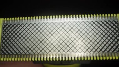 Bir Elektrikli Usturanın Bıçak Başının, Kılavuz Kalıpları ve Sarı Kesicilerin Detaylı Görünümü, Karanlık Bir Arkaplana Karşı Tasarım ve Fonksiyonelliği Vurguluyor