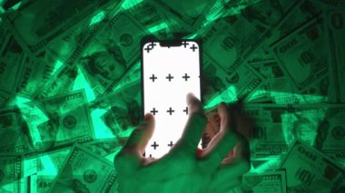 Beyaz Ekran Modelleri ve İzleme İşaretleri ile Akıllı Bir Telefona Parmak Ucu Yakınlaştırma Hareketi Yapan Bir Elin En İyi Görüntüsü, ABD Yüz Dolarlık Faturaların Yeşil-Parlak Arkaplanı, Teknoloji ve Etkileşimi Temsil Eden